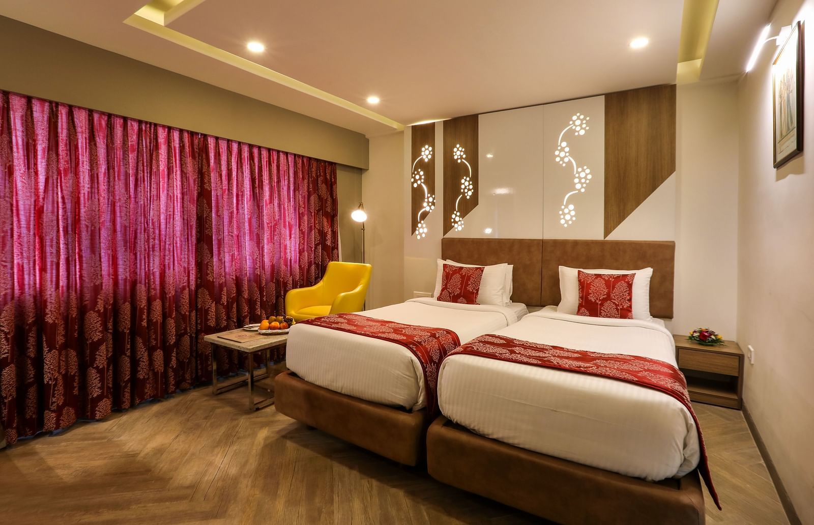 A bedroom with two single beds and a sofa and small table on one end beside the windows - Mango Hill Central, Chennai