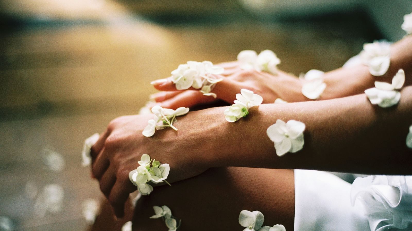 Close-up of arms adorned with delicate white flower petals