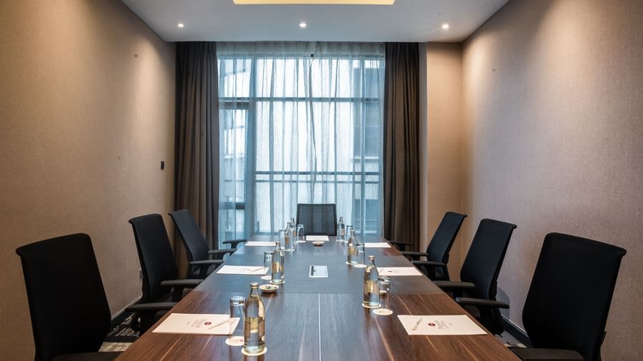 Meeting room inside Best Western Premier Westlands with a long table, chairs, notepads, and water glasses