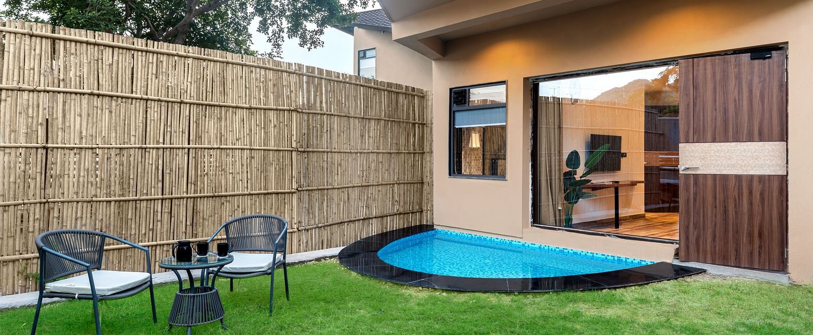 Luxury Villa with Plunge Pool featuring a  private outdoor area with a small plunge pool, surrounded by a bamboo fence and lush greenery at The Qualia Resort Club & Brewery, Udaipur.
