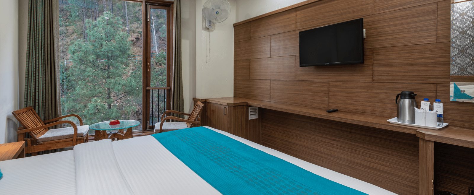 A bedroom featuring a seating area with a table and two chairs near the window at DLS Hotels The Rock Castle.