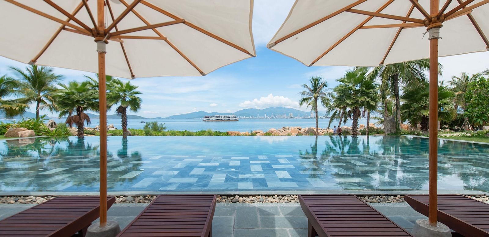 A pool side view of our resort on a sunny day - Alibu Resort Nha Trang