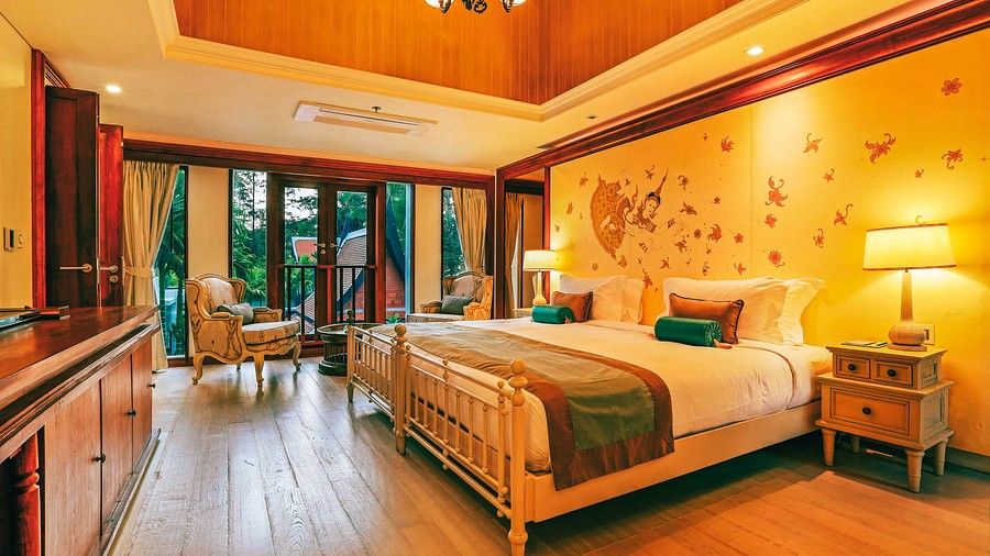 image of a bedroom with yellow lighting featuring a double bed - three bedroom private pool villa