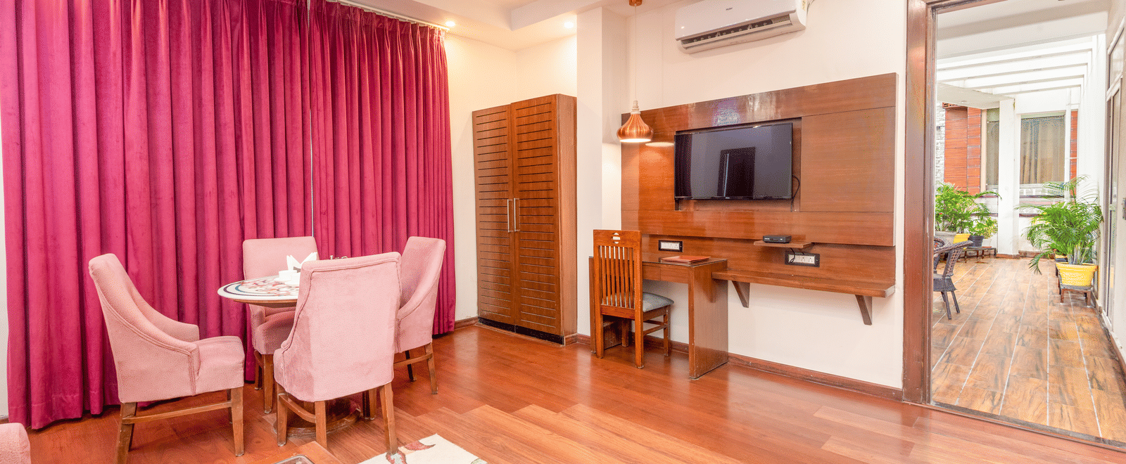 Spacious suite with seating area, TV, and balcony at DLS Hotels On The Ganges.