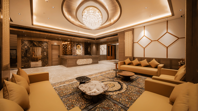 A spacious waiting lounge with plush tan sofas, patterned rugs, and elegant ceiling fixtures at Ananta Express, Katra.