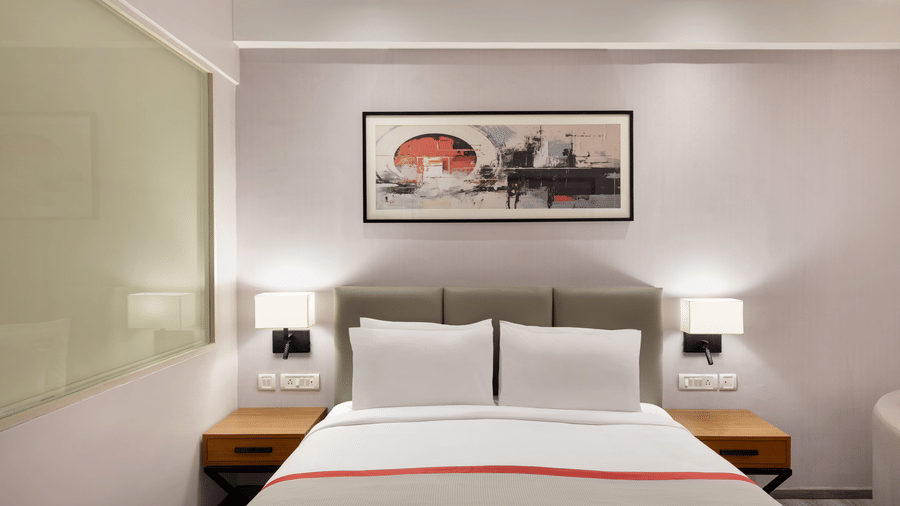 The Standard King Room featuring a comfortable bed with a painting on a wall at Ramada by Wyndham Bodh Gaya Mahabodhi.