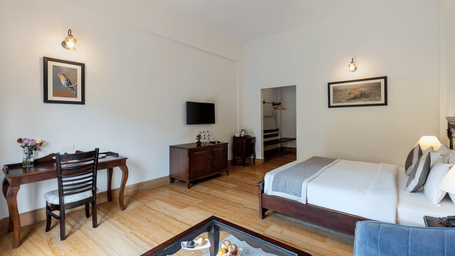 A wide-angle shot of the Hill View Suite With Balcony featuring a dedicated work desk and chair in a sleek modern interiors at The Hunting Lodge, Udaipur.