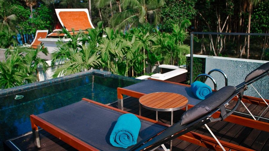 image of two sunloungers with blue towels kept on each - three bedroom private pool villa