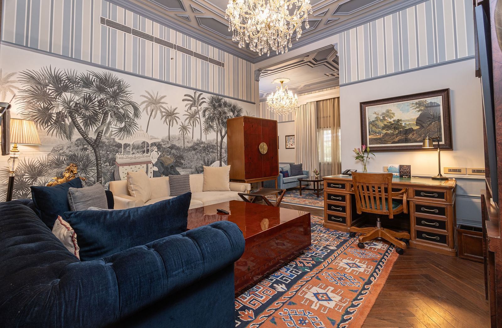 image of the living area with ample seating area for the guests with blue and white striped wallpaper at our heritage parlour suites - The Claridges New Delhi