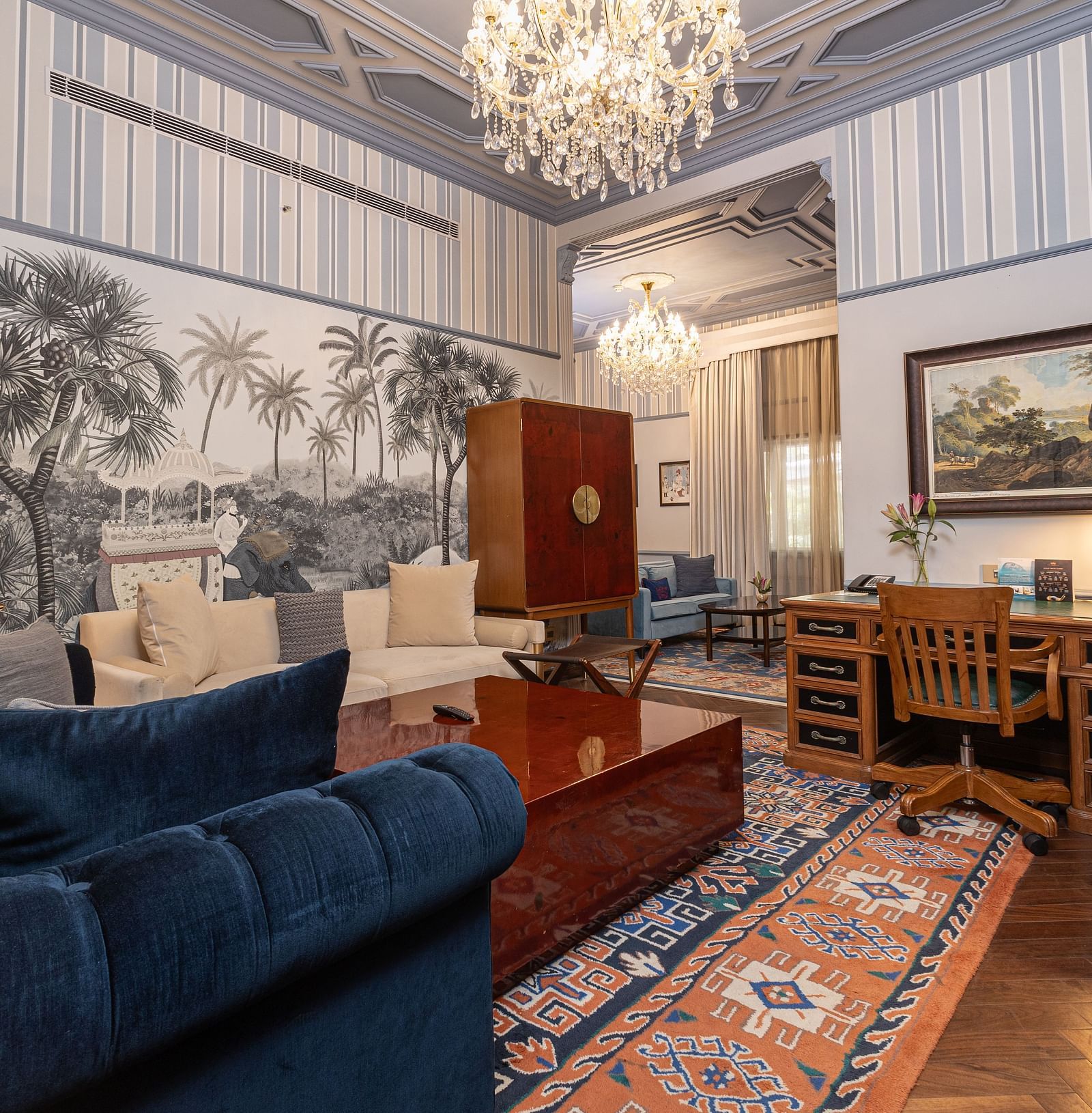 image of the living area with ample seating area for the guests with blue and white striped wallpaper at our heritage parlour suites - The Claridges New Delhi