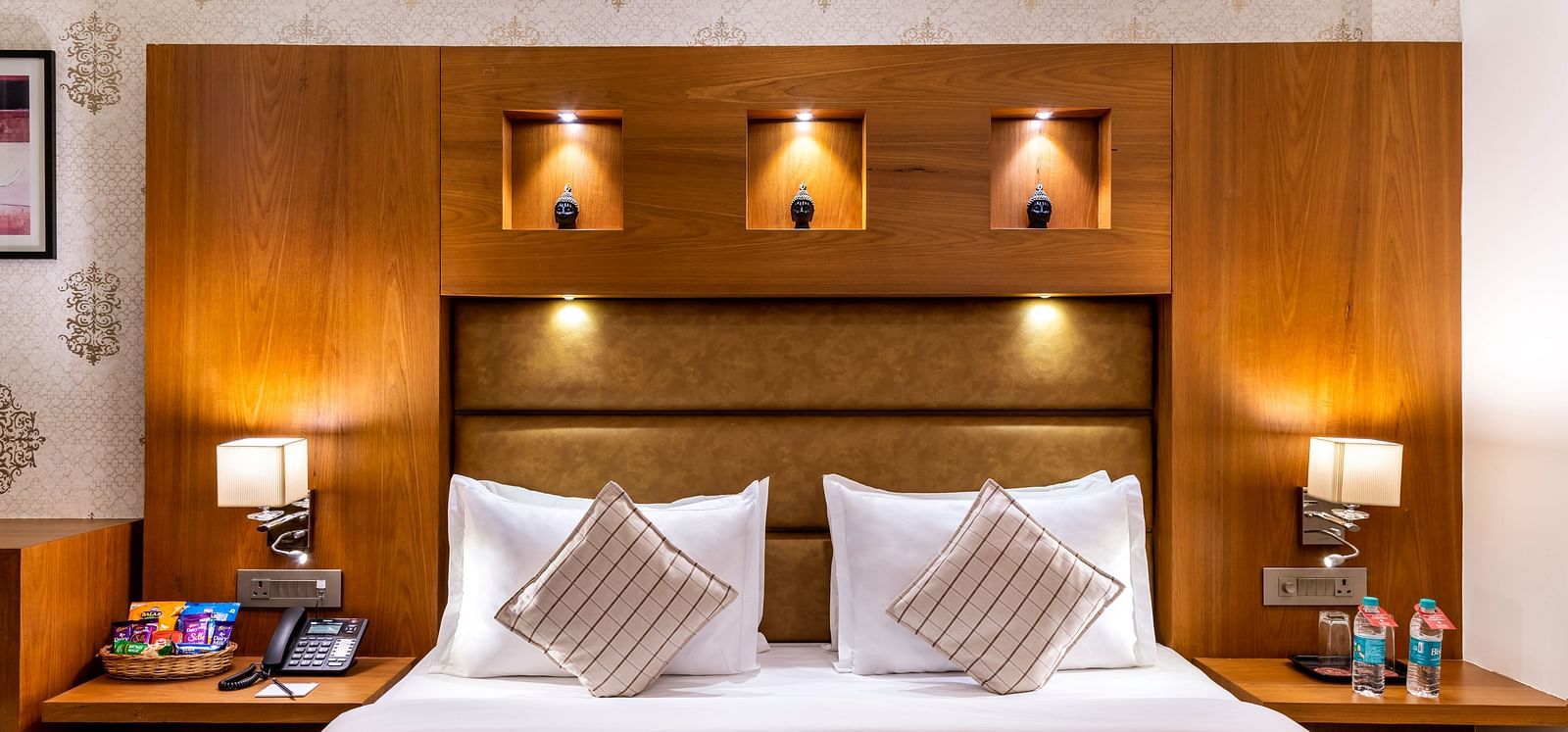 A comfortable king-sized bed with bedside tables and lamps in a hotel room at the Dwarkadhish Lords Eco Inn.