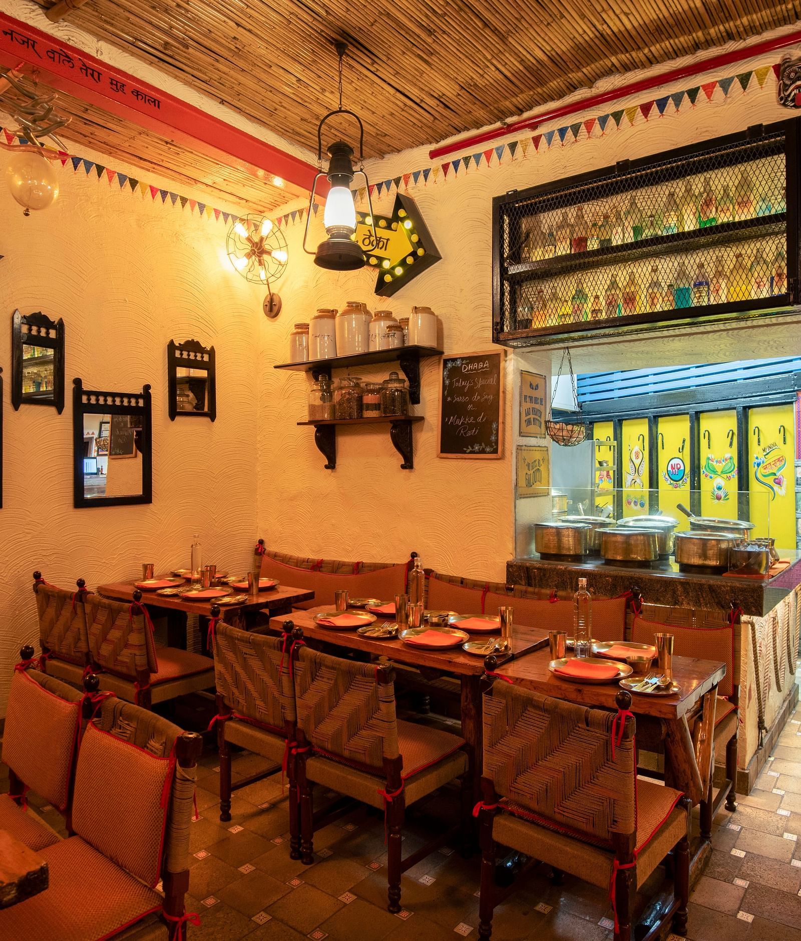 Image featuring the Dhaba dining area at The Claridges New Delhi, showcasing an authentic vintage-inspired decor with rustic seating and hanging antique lamps