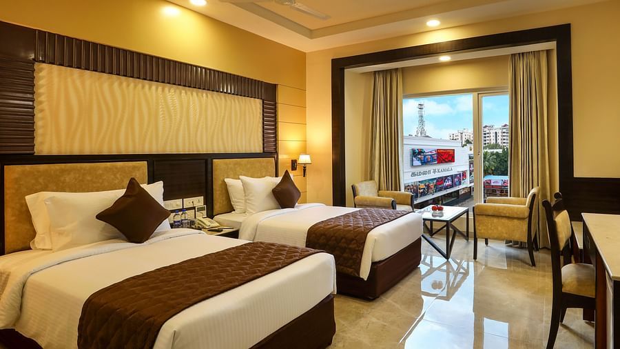 Brightly lit spacious Deluxe Twin Room with an attached balcony at Hotel Aadithya, Chennai
