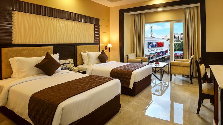Brightly lit spacious Deluxe Twin Room with an attached balcony at Hotel Aadithya, Chennai
