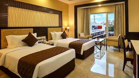 Brightly lit spacious Deluxe Twin Room with an attached balcony at Hotel Aadithya, Chennai