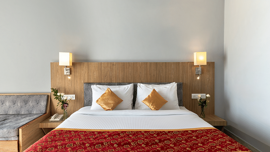 A hotel room with a bed, decorative pillows, a throw, and side tables with lamps - Via Lakhela Resort & Spa, Kumbhalgarh