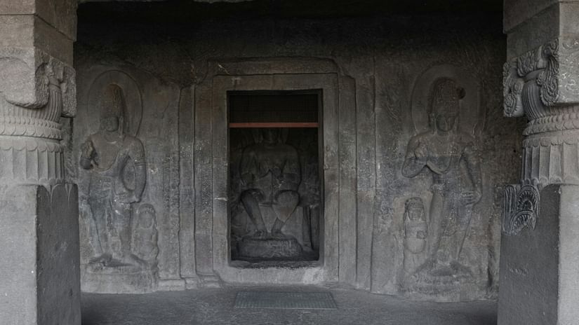 A cave temple with carvings, made from chisled rock.