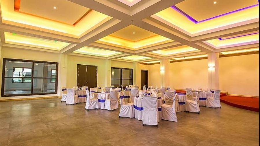 An image of a banquet hall with chairs where the hall is lit up with warm lighting - Yashshree Sanderling, Darjeeling