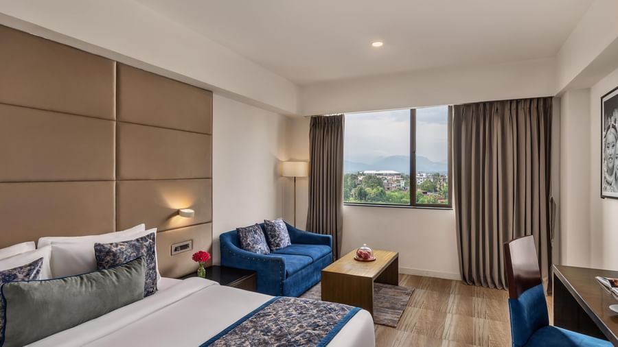 Guest room with large window and twin beds at Voyage Milestone Hotel and Banquet.