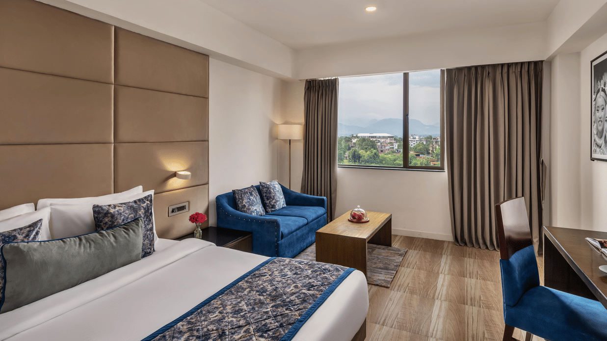 Guest room with large window and twin beds at Voyage Milestone Hotel and Banquet.