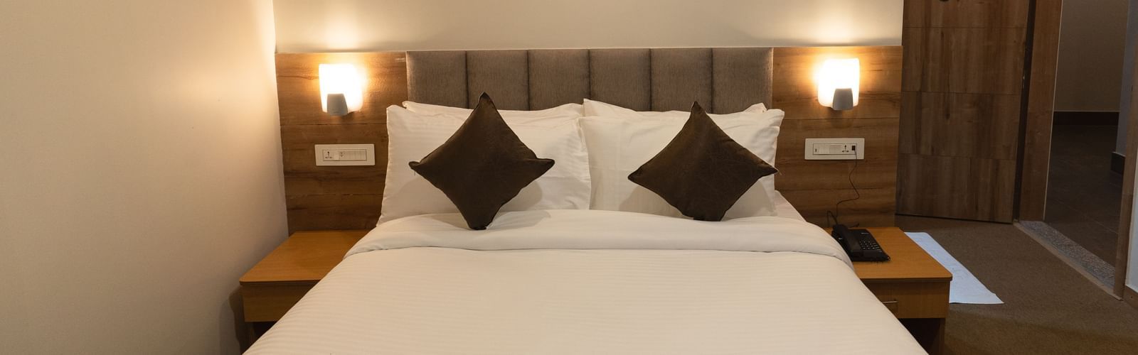 image of Deluxe room with two lamps on either side of the bed at The Soma Hotel by Avianna Group, Darjeeling