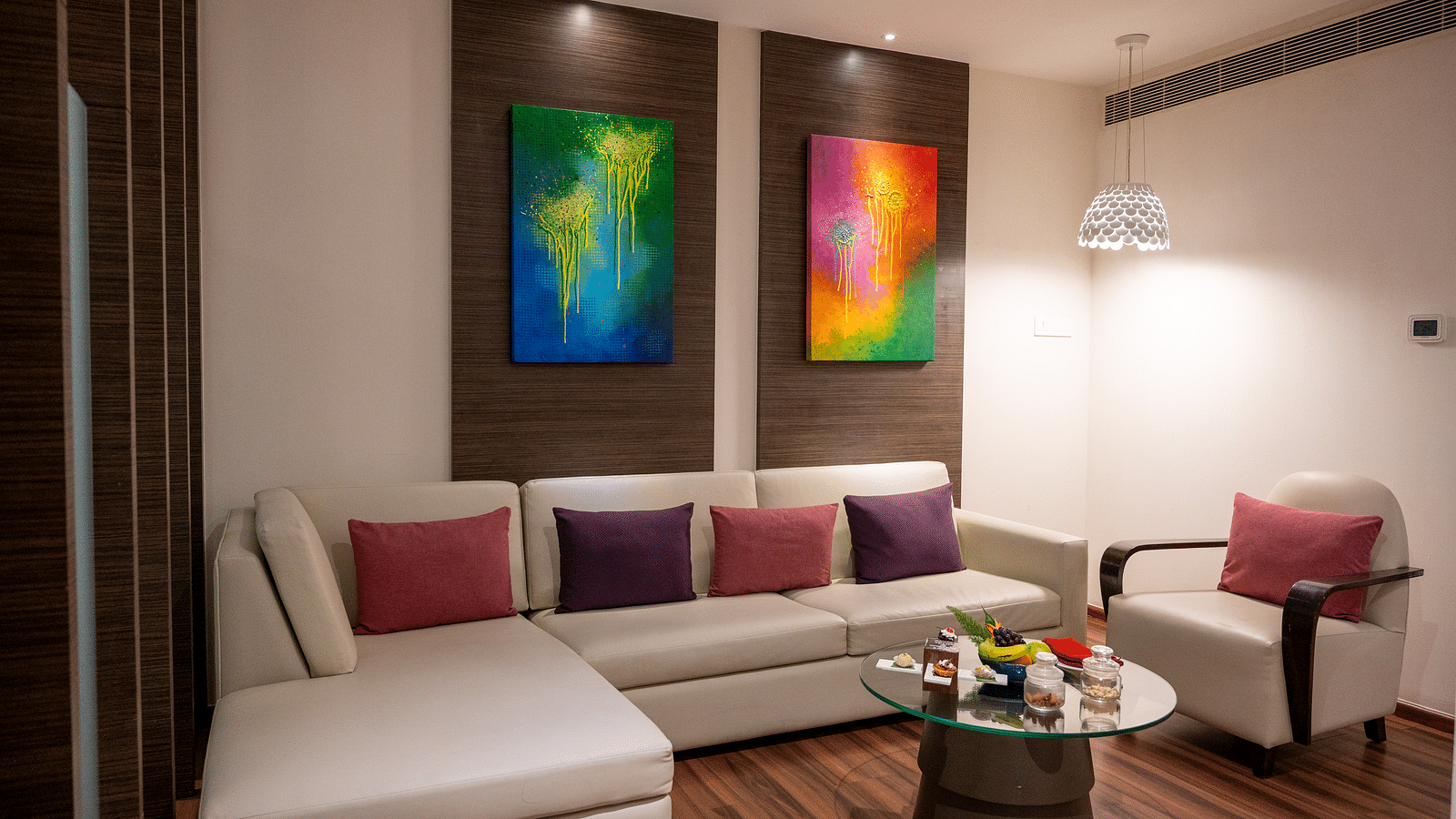 An image of suite living area with wall paintings and sofa sets at Grand Kakinada by GRT Hotels 