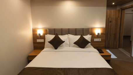 image of Deluxe room with two lamps on either side of the bed at The Soma Hotel by Avianna Group, Darjeeling