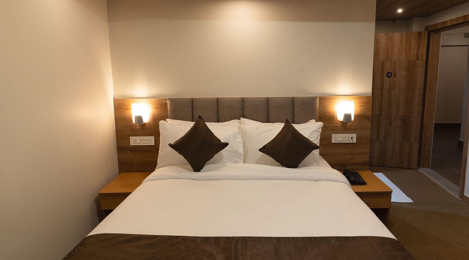 image of Deluxe room with two lamps on either side of the bed at The Soma Hotel by Avianna Group, Darjeeling