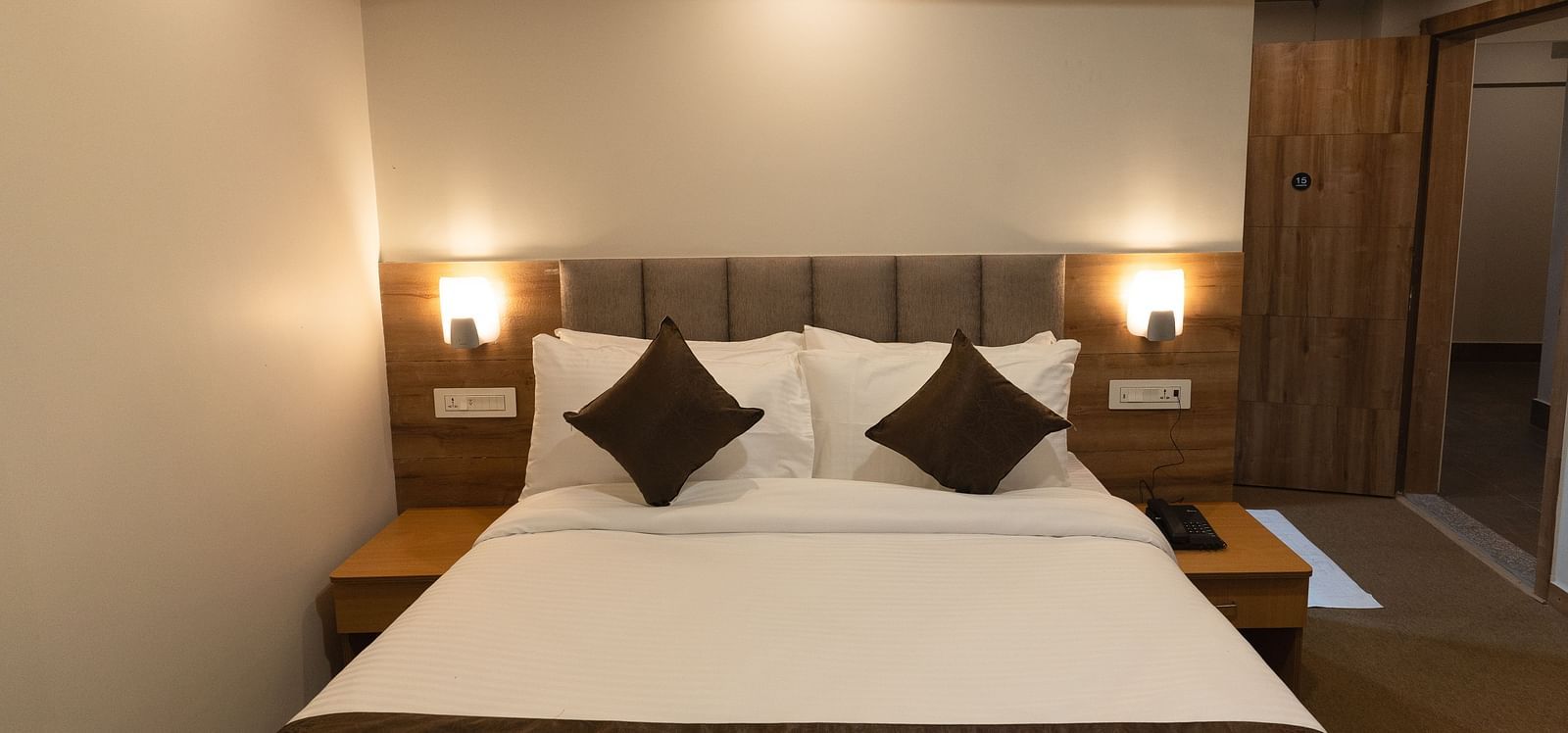 image of Deluxe room with two lamps on either side of the bed at The Soma Hotel by Avianna Group, Darjeeling