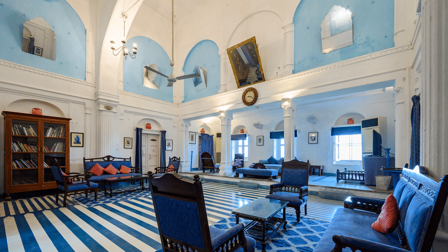 Darbar Hall featuring seating areas with wooden furniture and blue and white accent at Hill Fort-Kesroli, a heritage hotel in Alwar