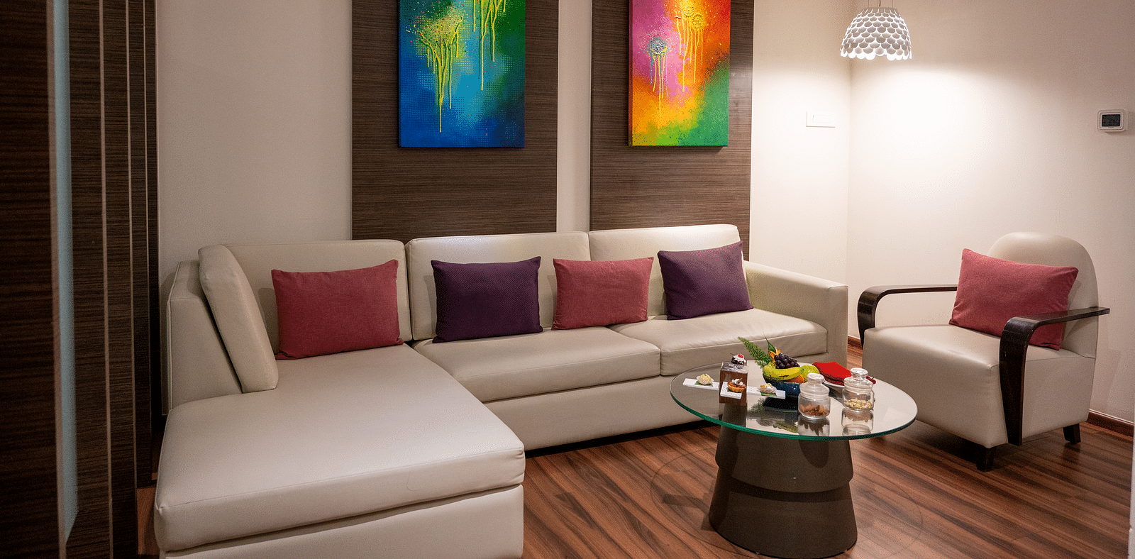 An image of suite living area with wall paintings and sofa sets at Grand Kakinada by GRT Hotels 