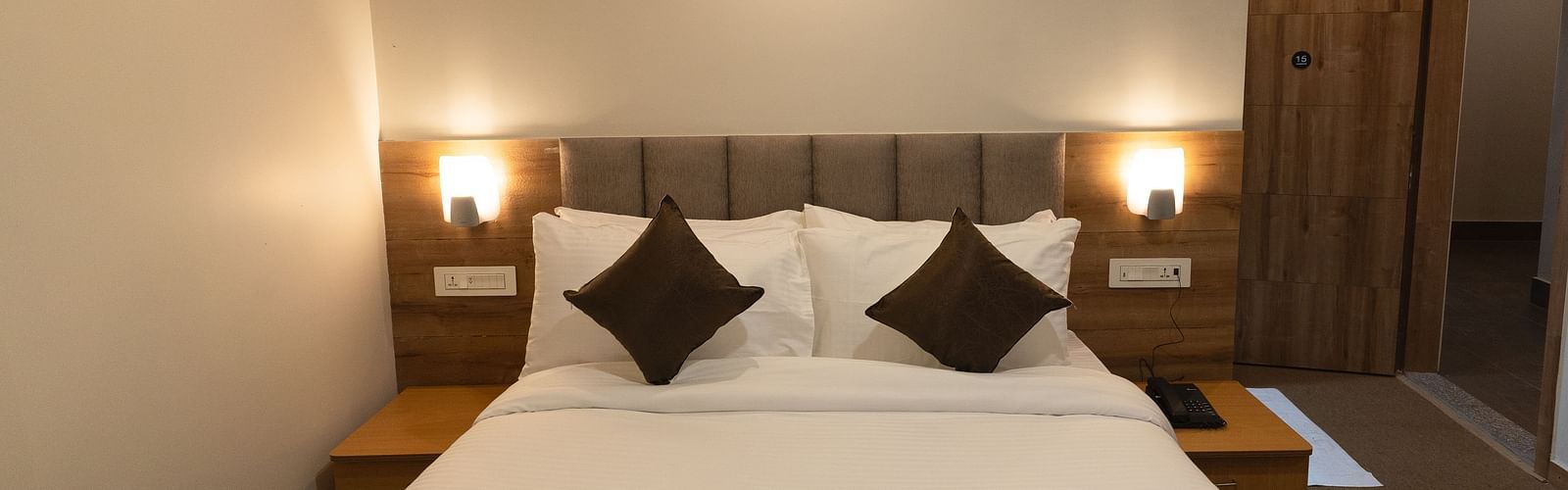 image of Deluxe room with two lamps on either side of the bed at The Soma Hotel by Avianna Group, Darjeeling