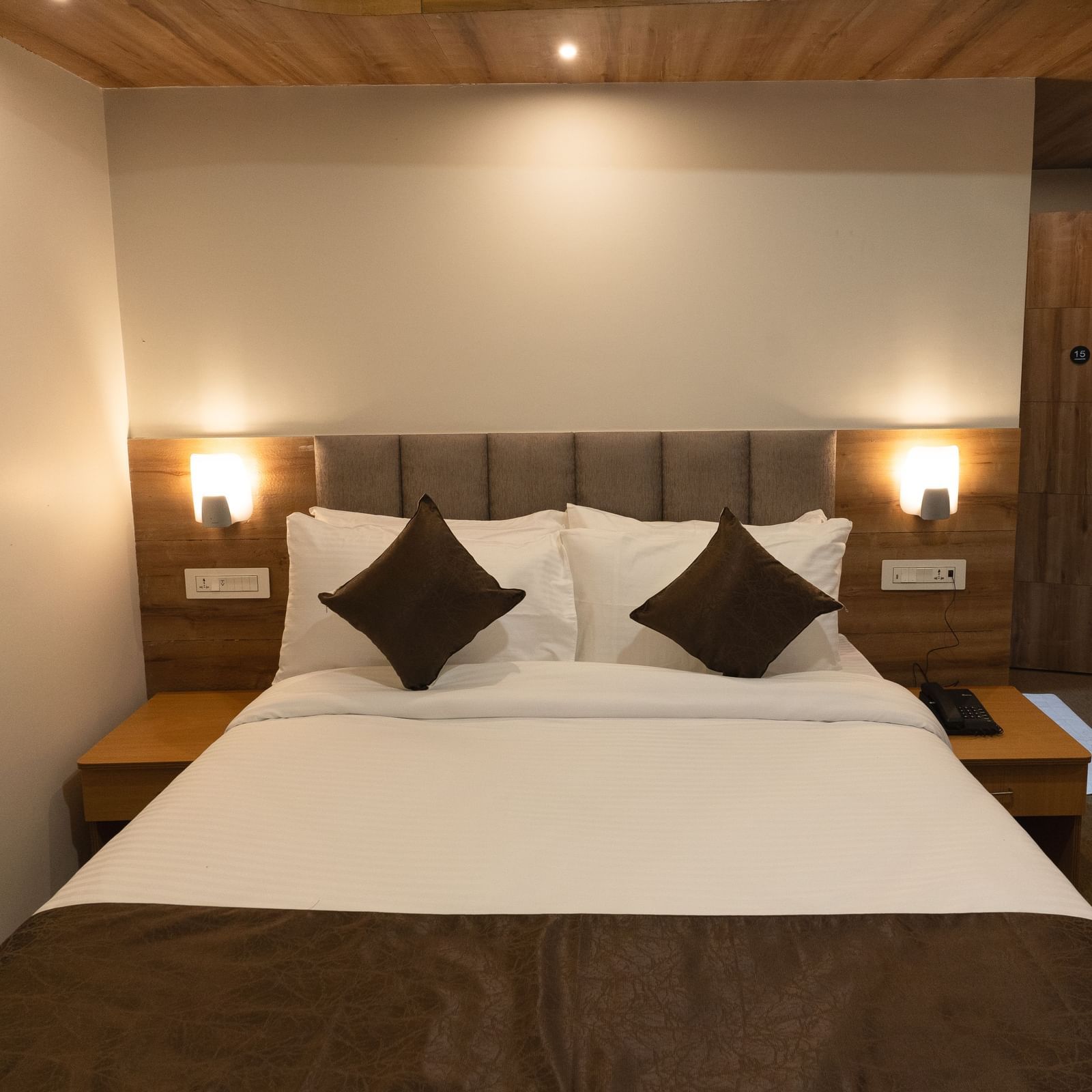 image of Deluxe room with two lamps on either side of the bed at The Soma Hotel by Avianna Group, Darjeeling