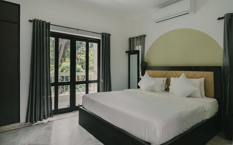Stylish bedroom with natural lighting and large windows in the Three BHK Deluxe Villa at Richmonde Ananta Elite, Goa.