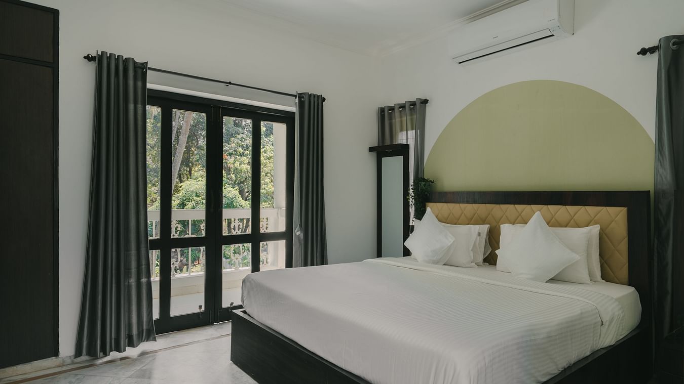 Stylish bedroom with natural lighting and large windows in the Three BHK Deluxe Villa at Richmonde Ananta Elite, Goa.