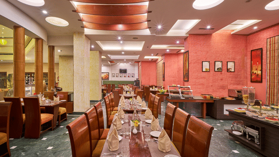 Interior dining area at HHI Varanasi featuring elegant seating, buffet setup, warm lighting, and a spacious restaurant ambiance.