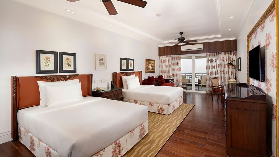 twin beds facing the TV positioned above a wooden cabinet - Mayfair Himalayan Spa Resort Kalimpong