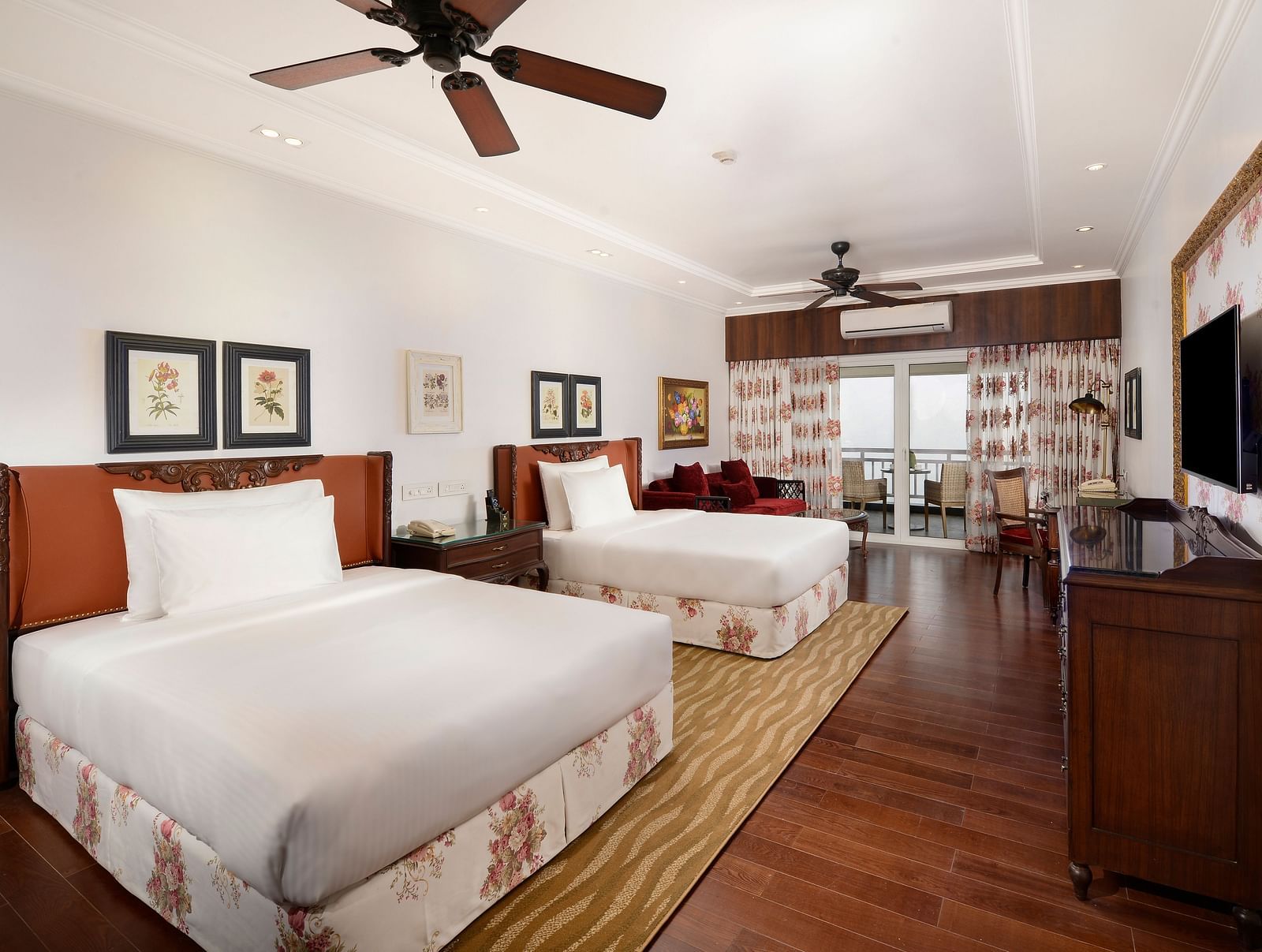 twin beds facing the TV positioned above a wooden cabinet - Mayfair Himalayan Spa Resort Kalimpong