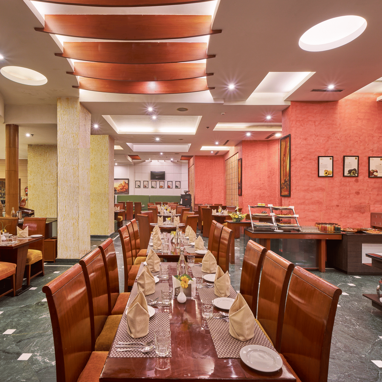 Interior dining area at HHI Varanasi featuring elegant seating, buffet setup, warm lighting, and a spacious restaurant ambiance.