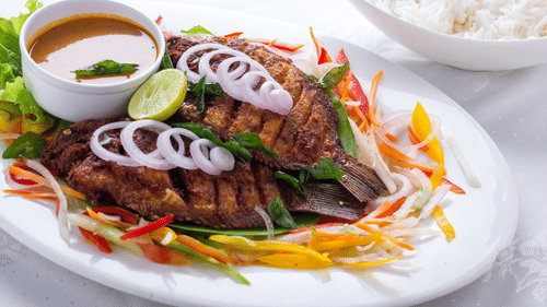 A garnished plate of fish fry and a bowl of rice at Abad Turtle Beach Resort, Marari Alleppey, the best reosrt in Alleppey.