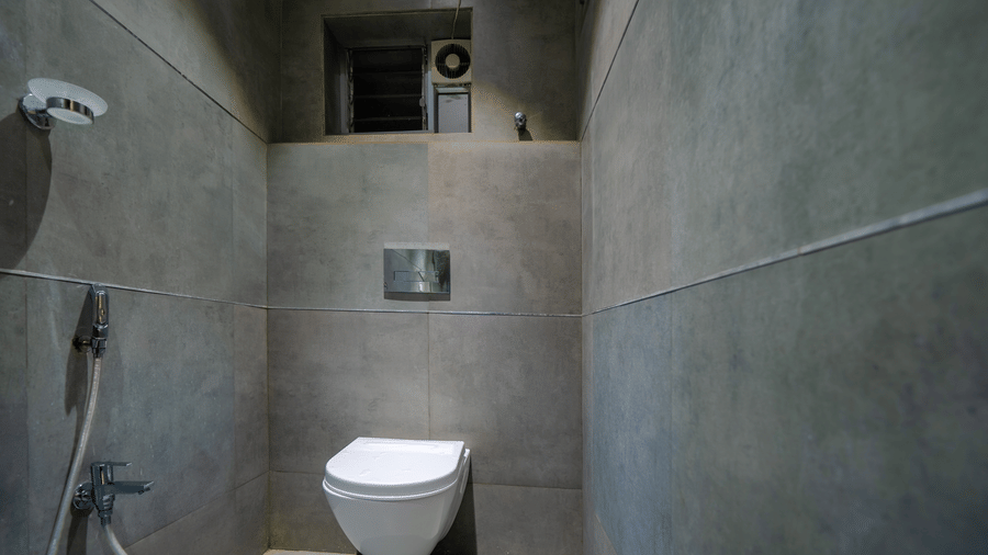Bathroom with grey tiles, a wall-mounted shower, and a water closet – Hotel Dolphin Puri