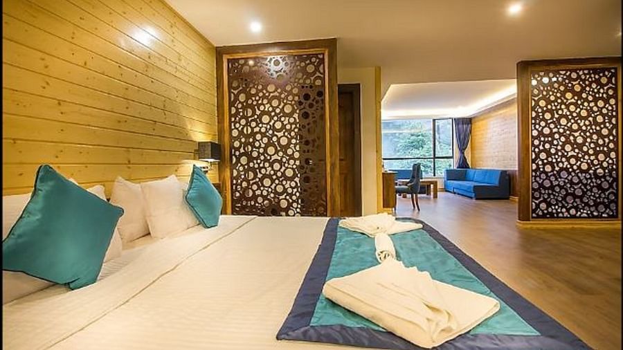 An image of a deluxe suite with a bed, lamps, and sofa set - Yashshree Sanderling, Darjeeling