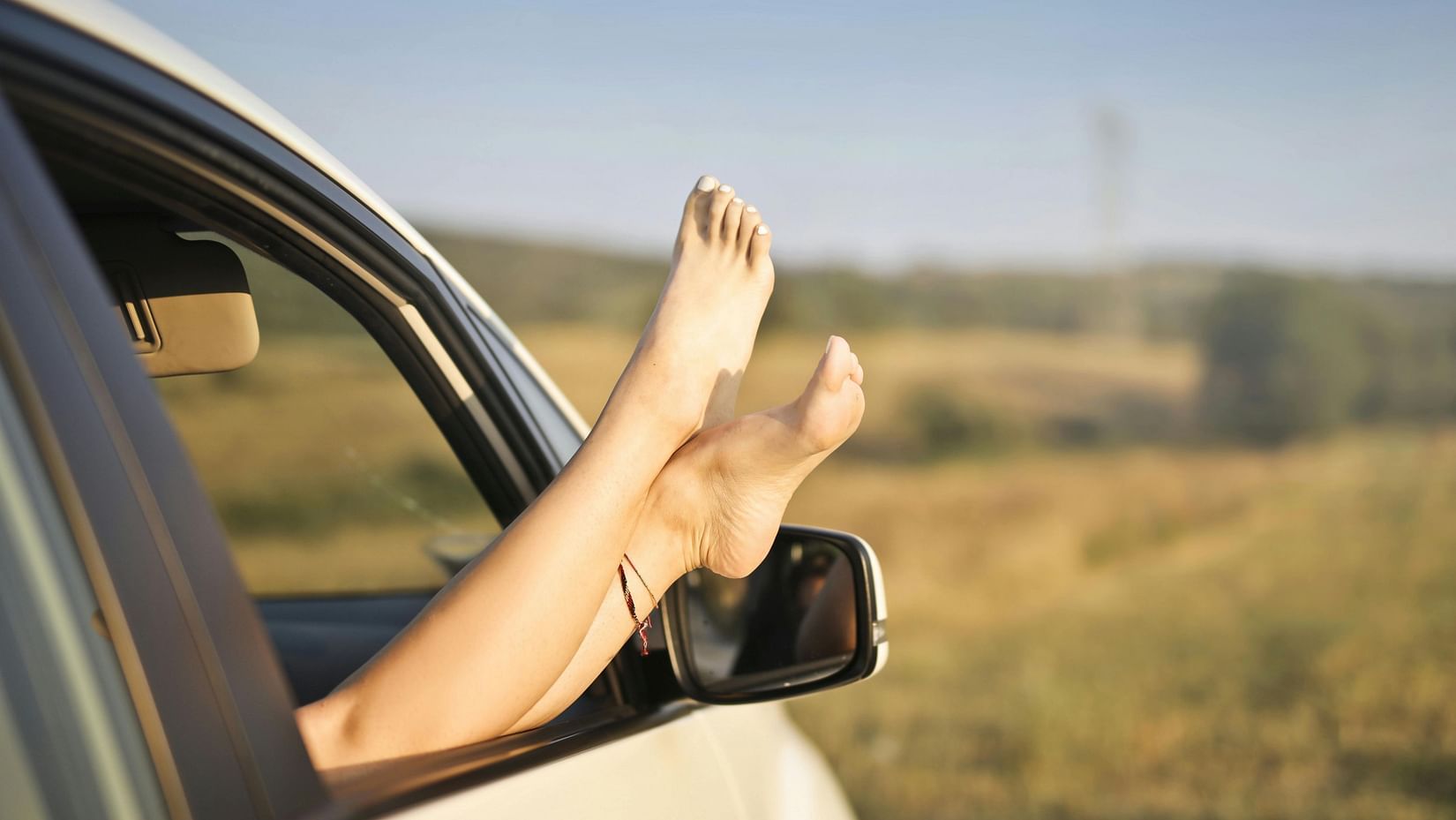 woman with legs sticking out of car window