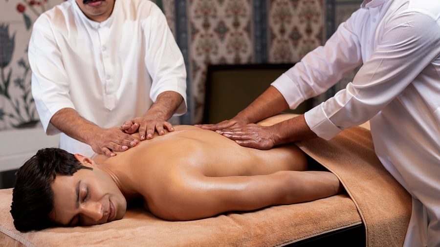 two experienced masseuse performing the synchronised abhyangam at the cinqtuair spa - The Claridges New Delhi