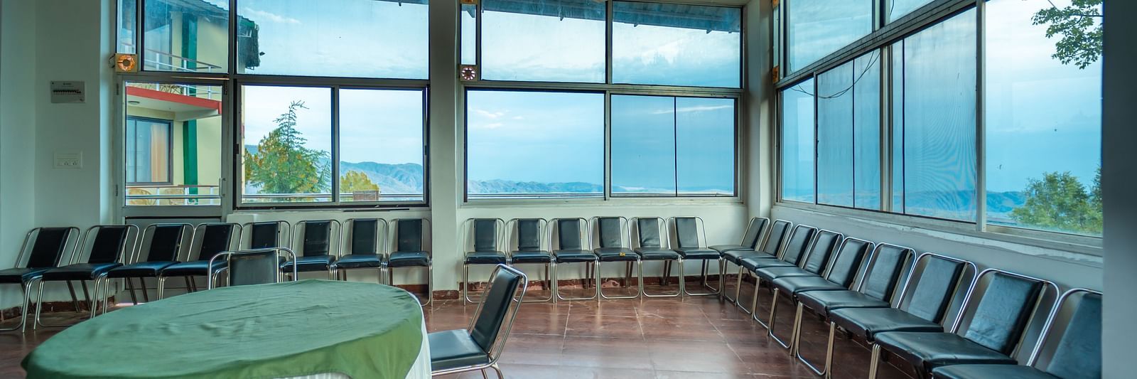 Banquet at Flutter Hotels and Resorts with round table, aligned chairs and glass windows overlooking the valleys.