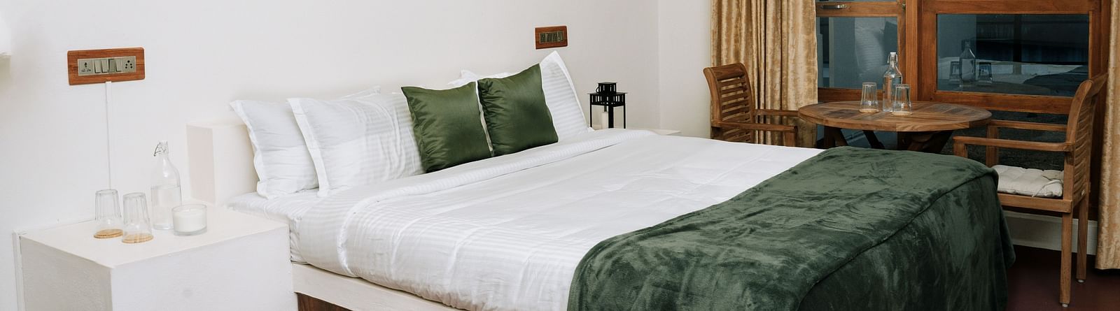 A bed in a room that has a glass window | Habba Dates Villa, Hampasandra