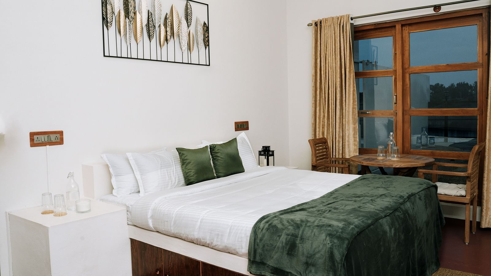 A bed in a room that has a glass window | Habba Dates Villa, Hampasandra