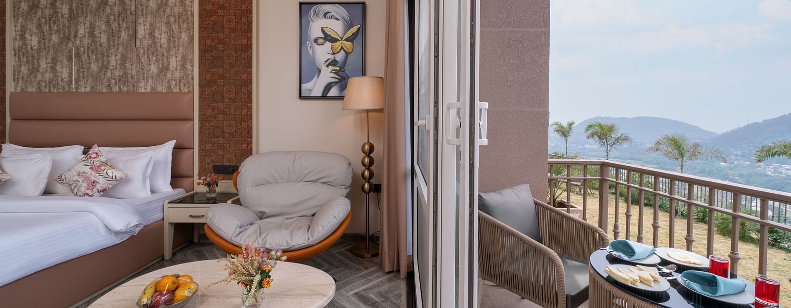 an image of a bedroom on one side with a single sofa and next to the room is a balcony with a seating arrangement -  Mountoria Retreat, Naukuchiatal
