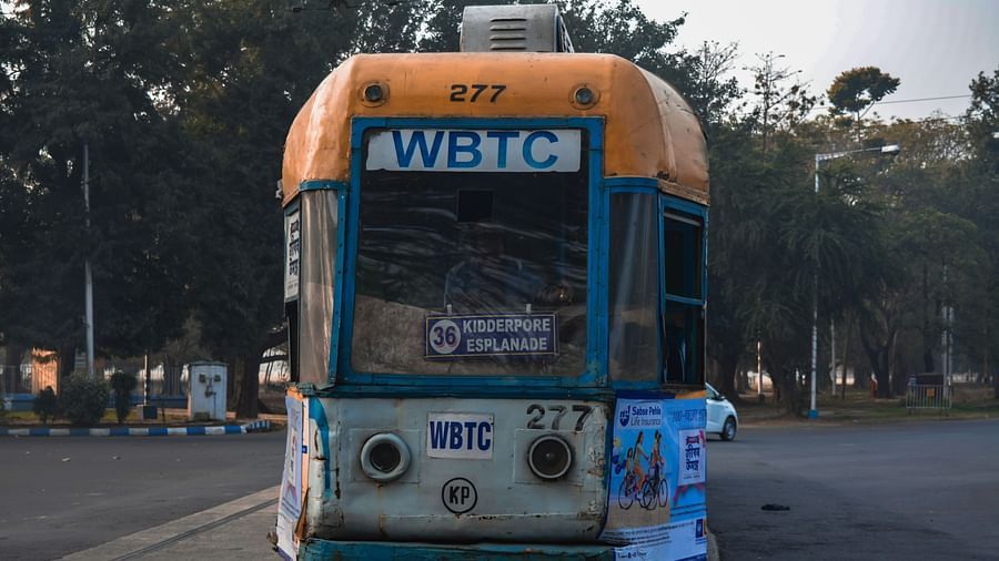 an overview of a yellow coloured tram in kolkata on the road