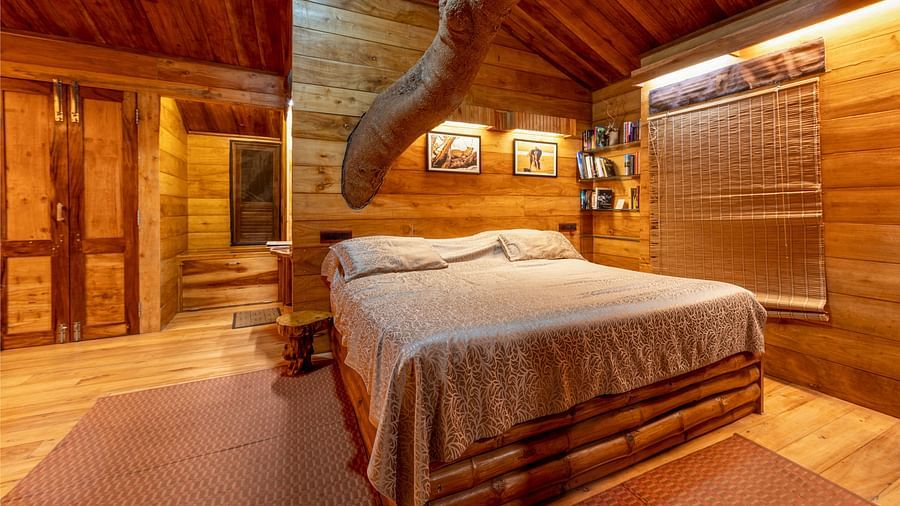 Cosy wooden tree house bedroom with a double bed and warm and inviting lighting - BluSalzz Collection - Tranquil Resort, Wayanad